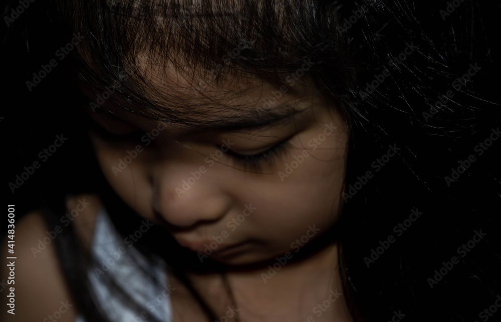 Powerful shot of a sad asian child. Female asian child sad dark scene Powerful shot of a sad asian child. Female asian child sad dark scene