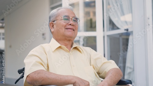 Photos Disabled senior man sitting on wheelchair alone in rehabilitation center, Portra