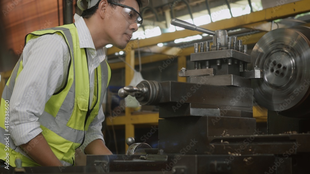 Asian professional mechanical engineer or operation man wear uniform goggles safety working on workshop metal lathe industrial manufacturing factory, Heavy industry lathe worker man, Asian professional mechanical engineer or operation man wear uniform goggles safety working on workshop metal lathe industrial manufacturing factory, Heavy industry lathe worker man,