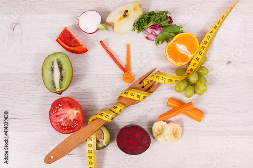 Tape measue with fruits and vegetables in shape of clock showing time to healthy eating and slimming