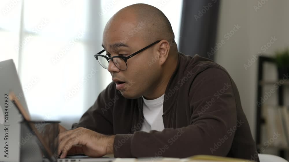 Tired businessman working with laptop. He covered his mouth with his hand and yawned. He is very sleepy. He work from home. Tired businessman working with laptop. He covered his mouth with his hand and yawned. He is very sleepy. He work from home.