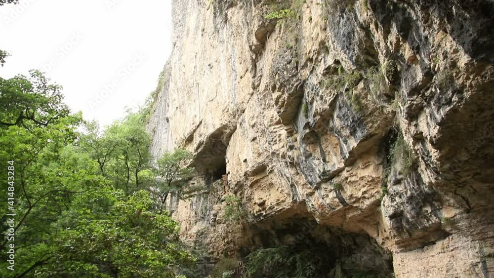 Natural Cave entrance in the rock near the forest Natural Cave entrance in the rock near the forest