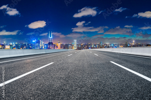 Empty asphalt road and Shanghai skyline with buildings at night.