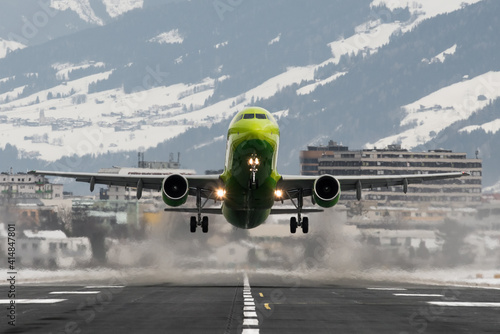 Wallpaper Mural Close up of a green passenger plane speeding on the runway and taking off at Innsbruck airport Torontodigital.ca