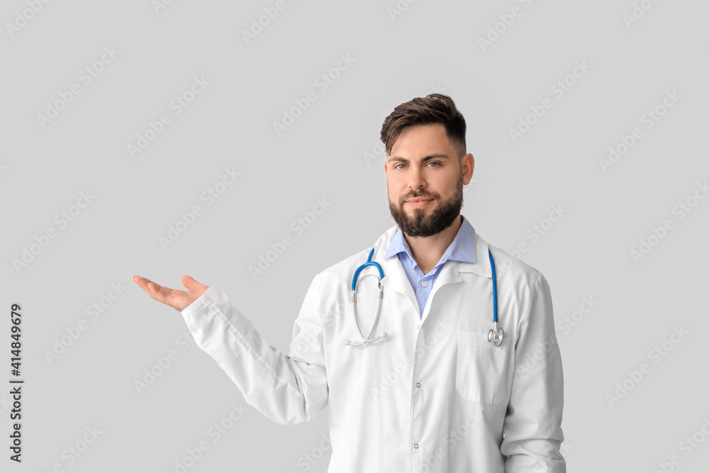 Doctor holding something on light background Doctor holding something on light background
