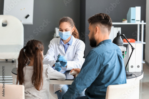Little girl and her father visiting allergist in clinic photo