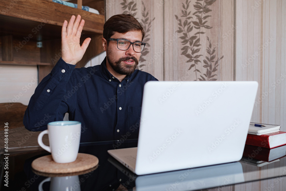 Focused man sitting at desk watching webinar video course Focused man sitting at desk watching webinar video course
