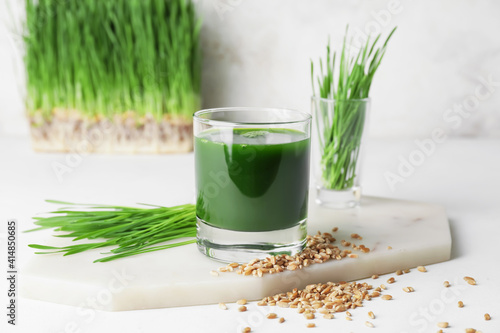Canvas Print Glass with fresh wheatgrass juice and seeds on light background