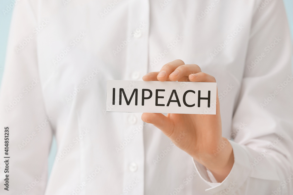 Woman holding paper with text IMPEACH, closeup Woman holding paper with text IMPEACH, closeup