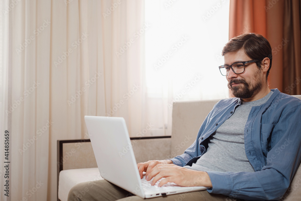 Handsome young man using laptop computer at home. Handsome young man using laptop computer at home.