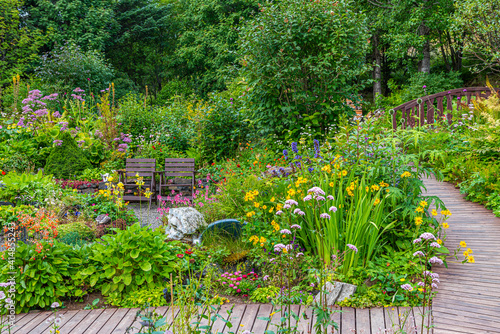 Two wooden chairs in a flourishing garden