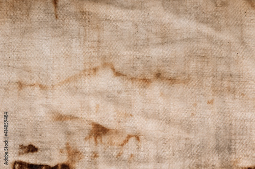 The texture of an old linen fabric, covered with dirt, rust and streaks. Background grange. Vintage rag.