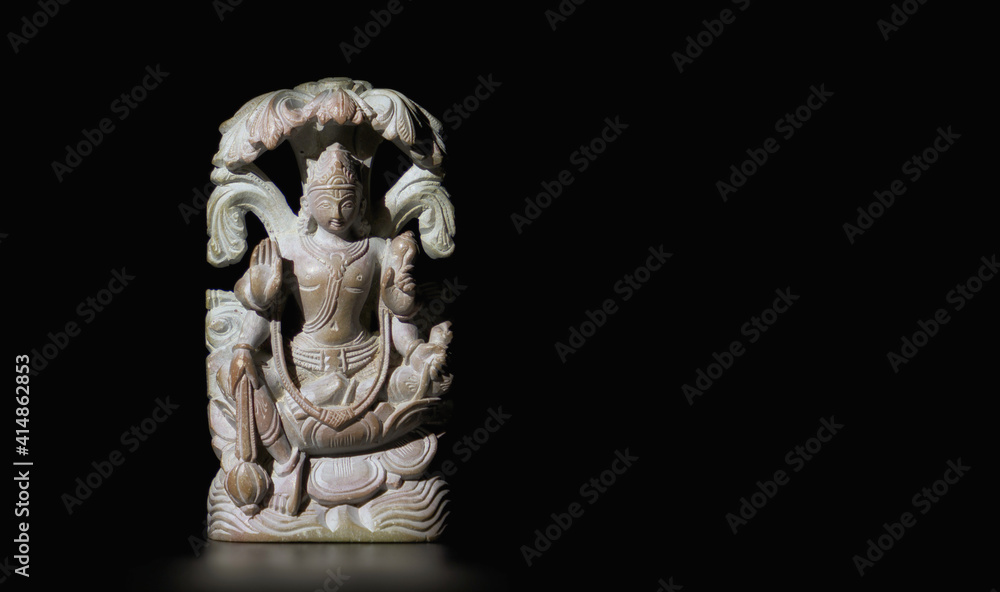 Buddhist figurine made of soapstone on a black isolated background. Close-up, banner, copy space. Buddhist figurine made of soapstone on a black isolated background. Close-up, banner, copy space.