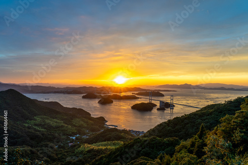 夕焼けをバックにライトアップされた橋と海