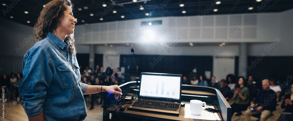 Businesswoman giving a presentation at a seminar in a corporate event - obrazy, fototapety, plakaty 