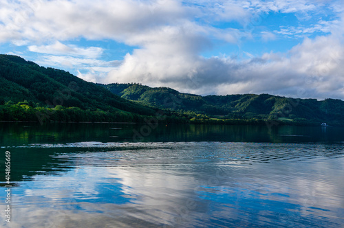 Fototapeta Naklejka Na Ścianę i Meble -  湖の湖面に反射する青い空と緑の山なみ