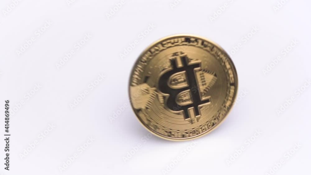 Gold bitcoin BTC rotating or rotates isolated on white background close-up. Macro shot of Bit coin model cryptocurrency spinning on table. Blockchain Technology. Gold bitcoin BTC rotating or rotates isolated on white background close-up. Macro shot of Bit coin model cryptocurrency spinning on table. Blockchain Technology.