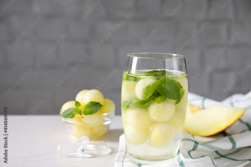 Tasty melon ball drink on white table. Space for text Tasty melon ball drink on white table. Space for text