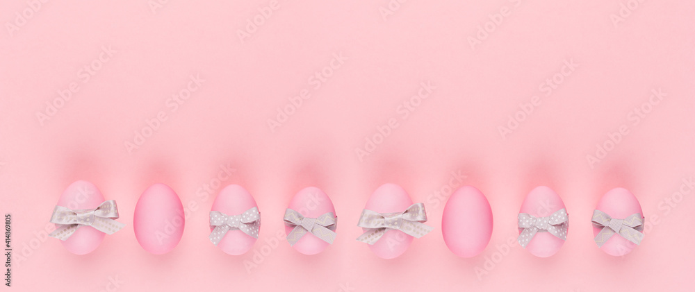 Fashion easter banner - pink eggs with grey ribbon and bow in row on pastel pink color.