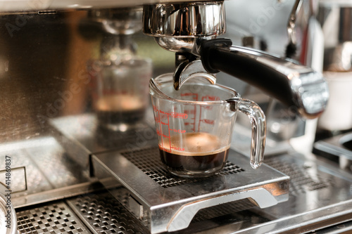 black coffee in measuring cup put on coffee maker © pariwatpannium