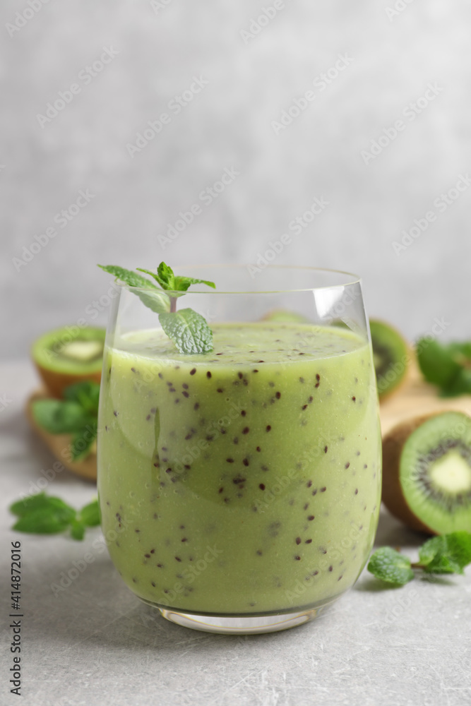 Delicious kiwi smoothie on light grey table Delicious kiwi smoothie on light grey table
