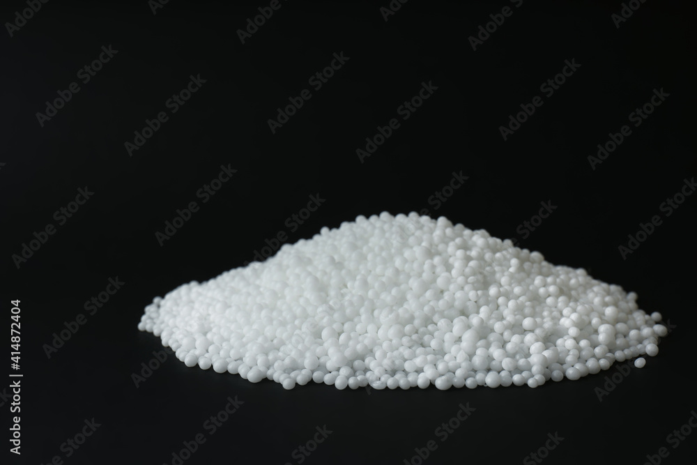 Pellets of ammonium nitrate on black background, space for text. Mineral fertilizer Pellets of ammonium nitrate on black background, space for text. Mineral fertilizer