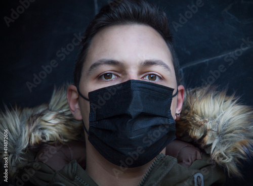 man with medical mask on the street with wall background photo