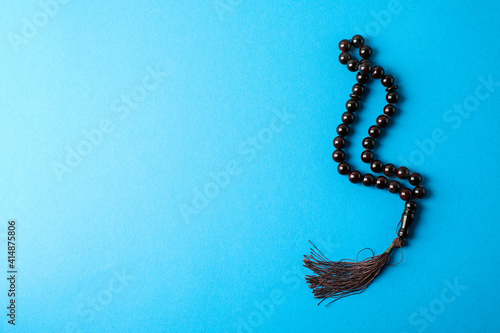 Rosary or prayer beads on blue background photo