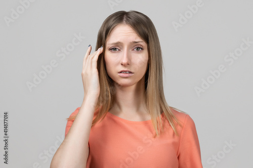 Concerned, frustrated young blond girl feeling fatigue, as suffer pain in head, painful headache or migraine