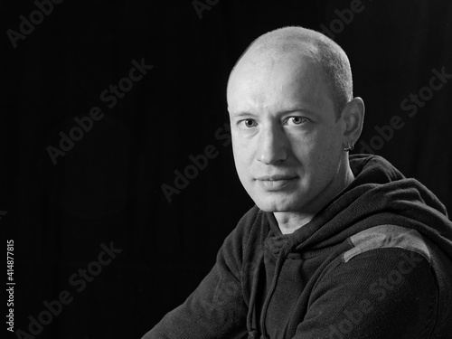 bw portrait of a bald man on a black background