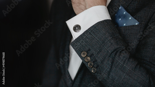 Hand men wears cufflinks close up. photo