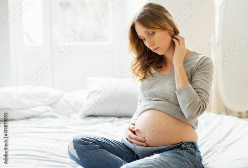 Portrait of young pregnant woman at home.