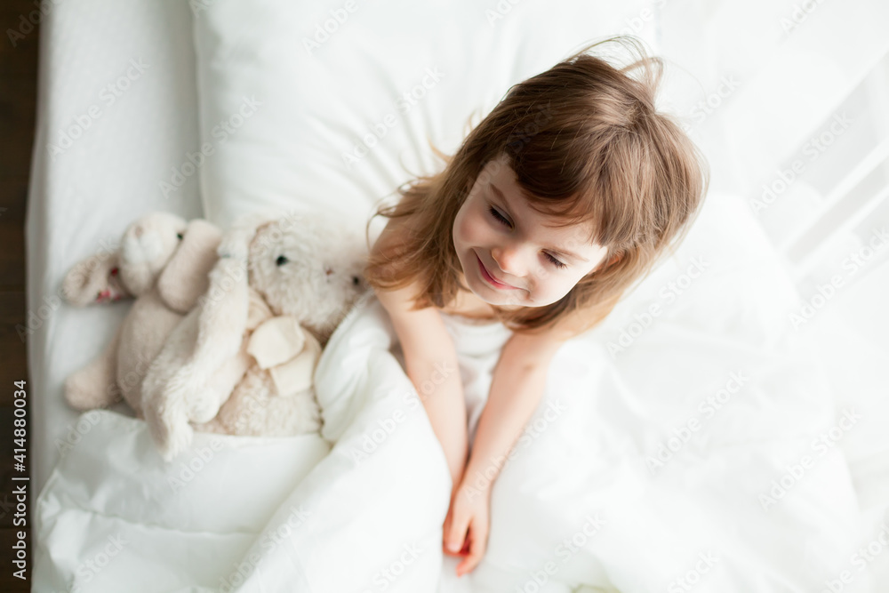 Beautiful little girl sitting in her bed Beautiful little girl sitting in her bed