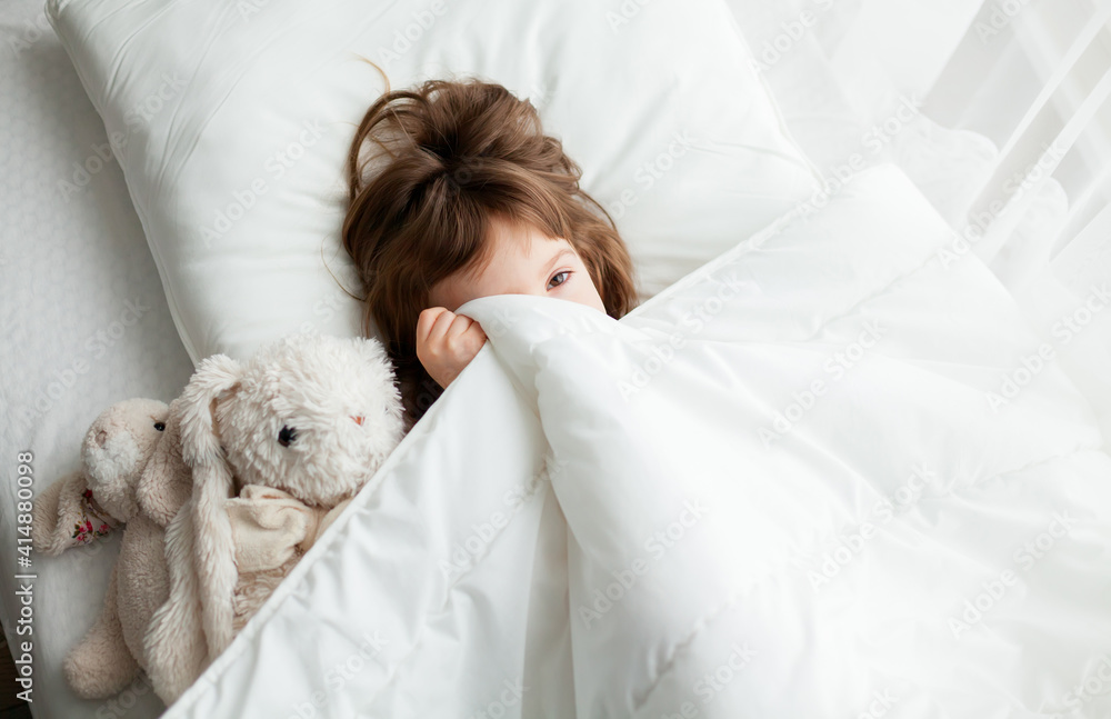 Little girl hiding under blanket Little girl hiding under blanket