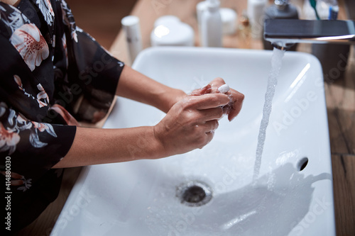 Woman is washing her hands with soap