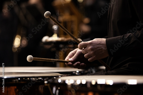 Hands of a musician playing the timpani in the orchestra close up