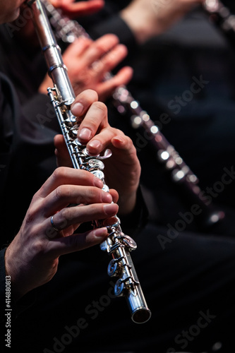Hands of a musician playing the flute close up