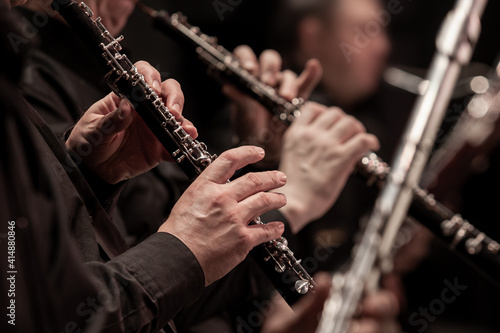 Hands of a musician playing the oboe in an orchestra