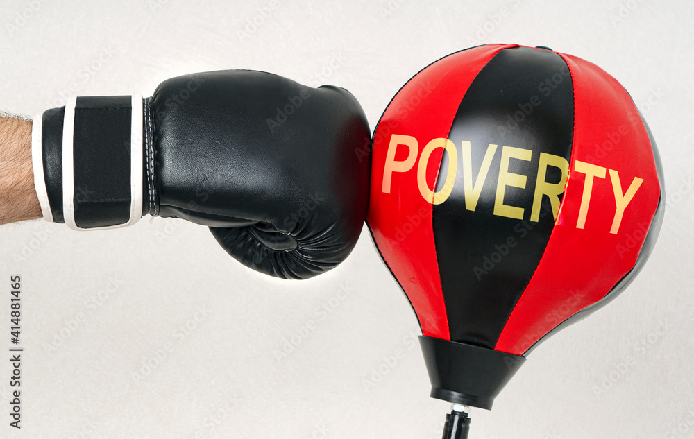 Ταπετσαρία Fight the poverty and misery concept with a strong man's hand in a boxing glove hits the punching bag with text Poverty