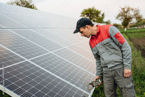 Man installing solar panels. An electrician or engineer works with solar panels. The future of alternative energy and sustainable energy.