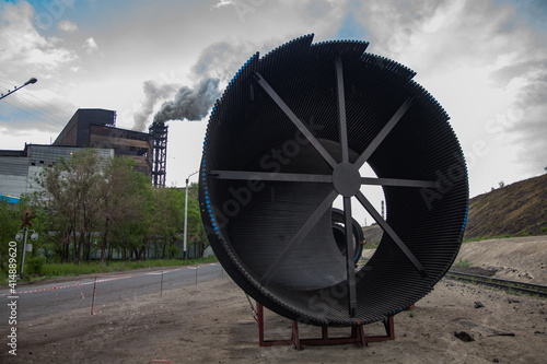 Modern metallurgy convertor gas cleaning filter on steel plant. Ready for installation. Oschatz equipment. Smoking plant chimney (smoke stack) on background. photo