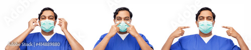 healthcare, profession and medicine concept - indian doctor or male nurse in blue uniform putting on face protective medical mask for protection from virus disease over white background