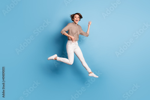 Full size portrait of cheerful person jump high hands playing imagine guitar isolated on blue color background