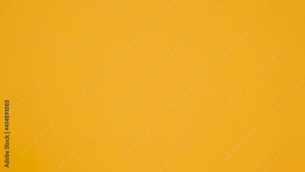 Teenage guy is going downstairs holding a lot of books on his head isolated on yellow studio background. Teenage guy is going downstairs holding a lot of books on his head isolated on yellow studio background.