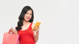 happy asian lady holding some shopping bags using her phone and credit. woman shopping concept