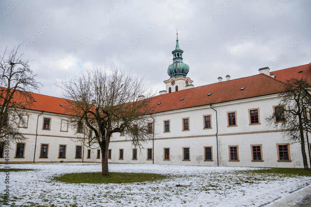 Fototapeta premium Baroque white benedictine monastery Brevnov with church, Medieval Basilica of St. Marquette, Garden and park, abbey under snow in winter day, Prague, Czech Republic