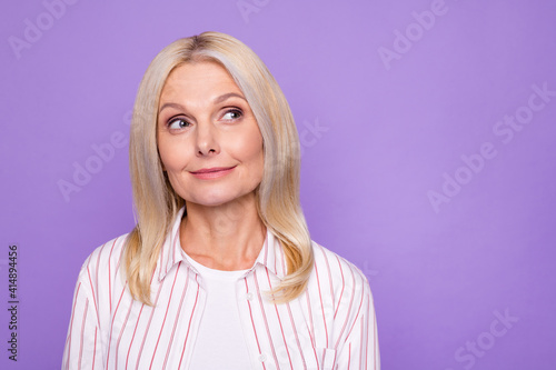Photo of charming adorable lady pensioner wear striped shirt looking empty space isolated violet color background