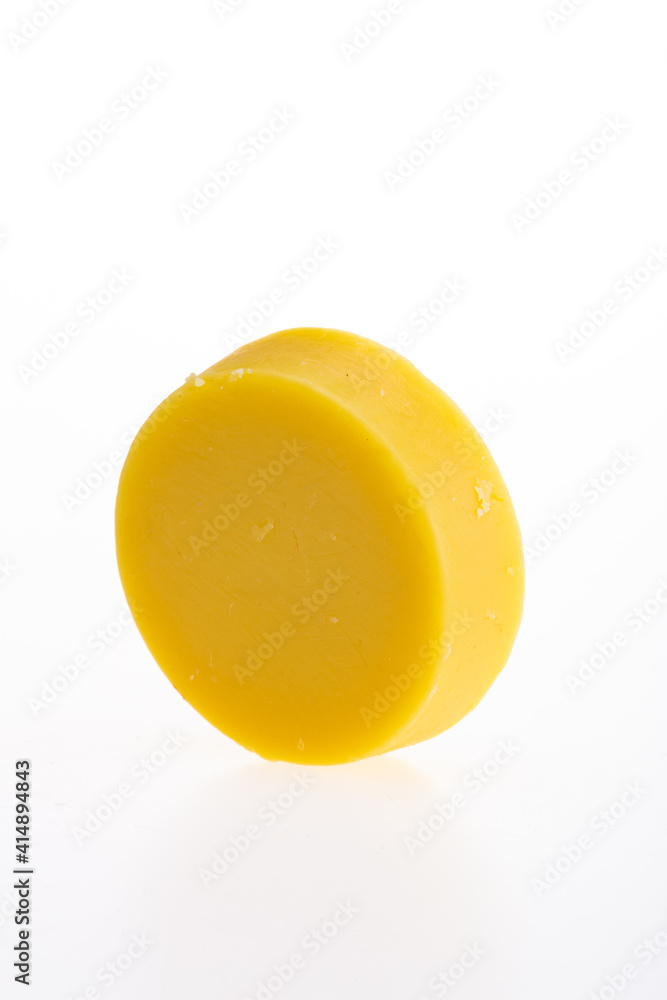 Yellow round piece of soap on a white background. 