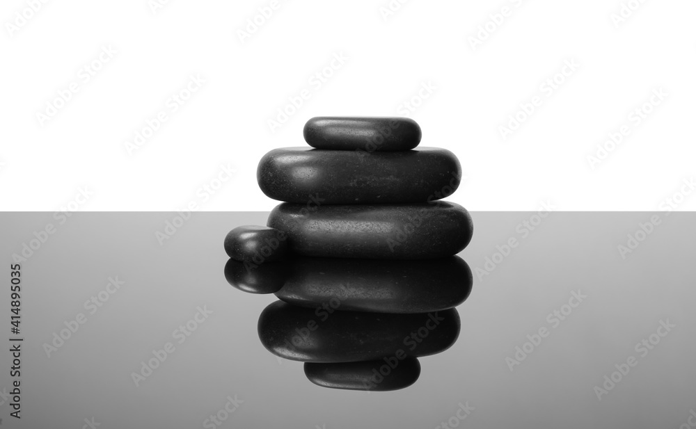 Stack of spa stones on mirror surface Stack of spa stones on mirror surface
