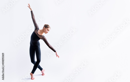 a ballet girl in a black tight-fitting suit dances on a white background with modern contemporary choreography